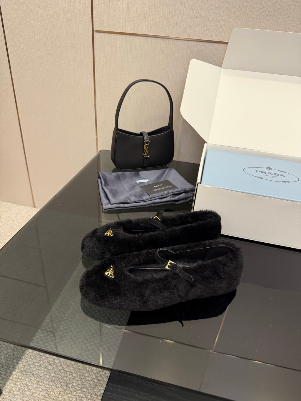 Prada women's black plush loafers with gold logo accents, angled view