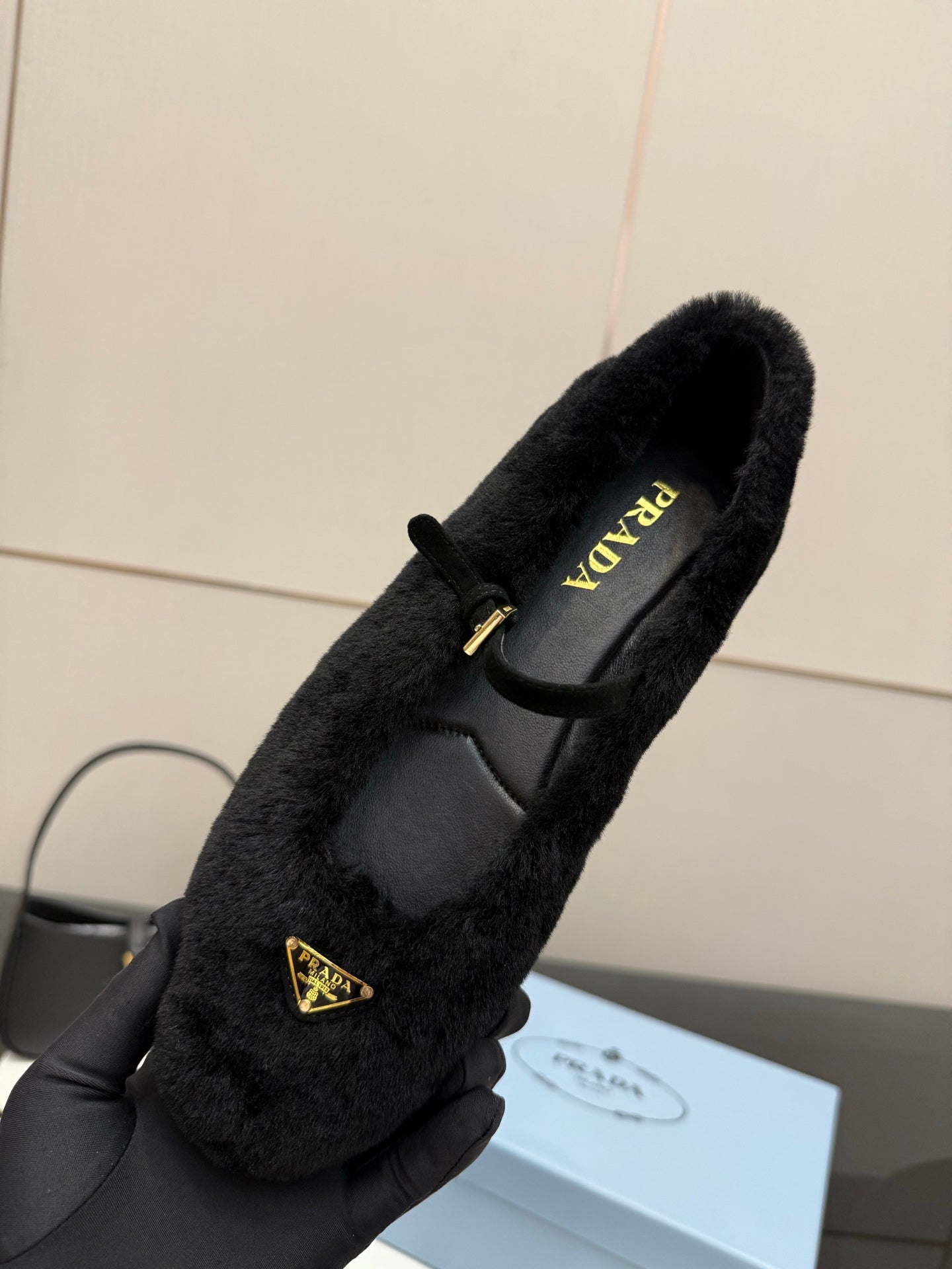 Prada women's black plush loafer in hand, PRADA logo on insole