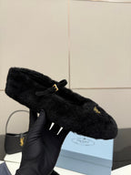 Prada women's black plush loafer held up, gold logo triangle detail