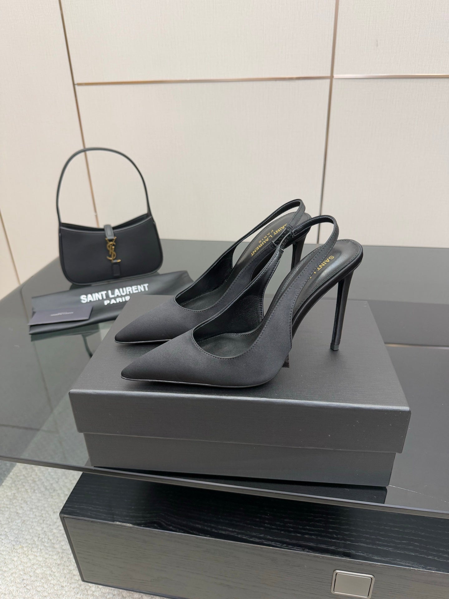 Women’s stiletto heeled pumps, dark leather, side view on display box