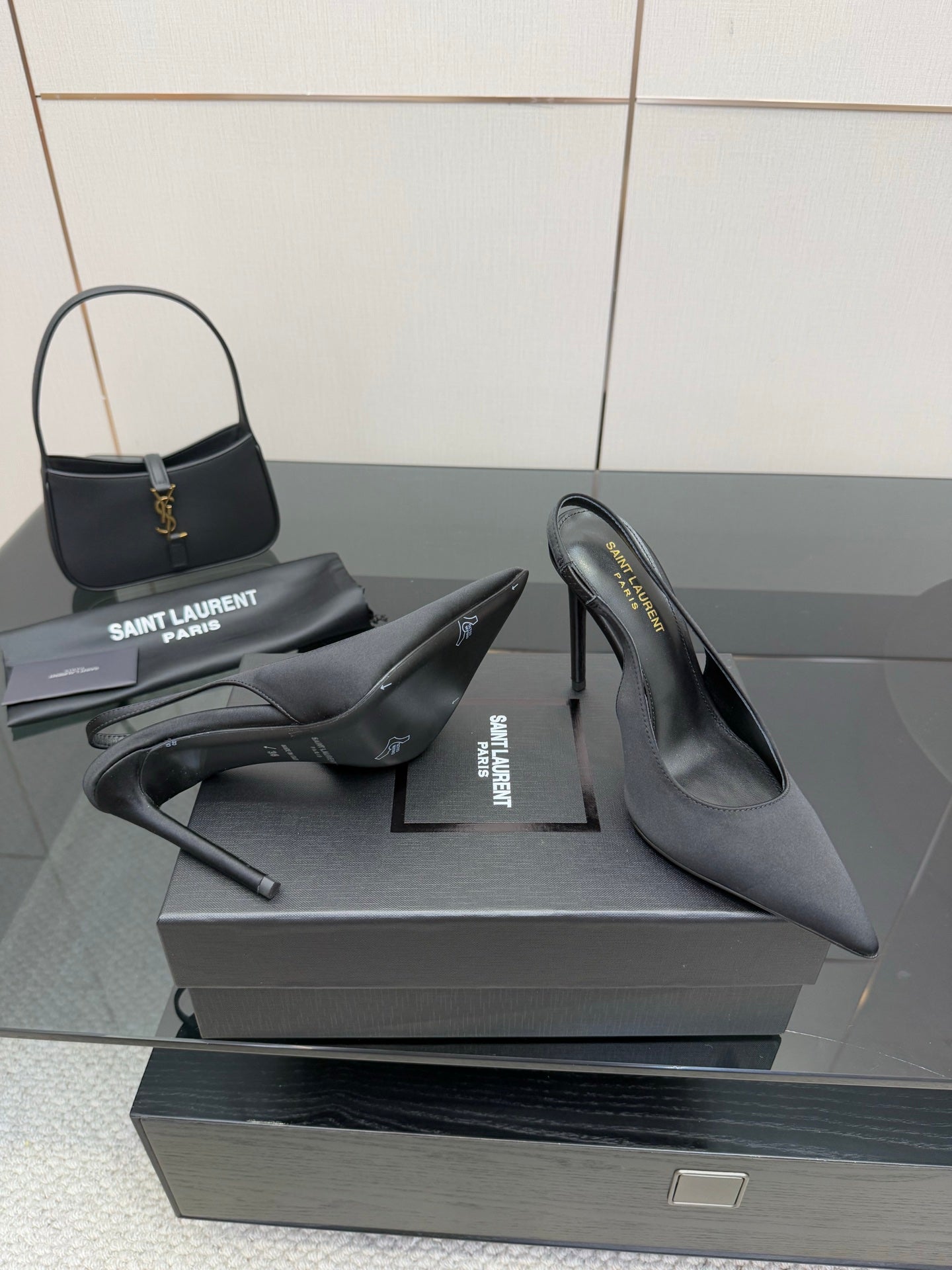 Women’s stiletto heeled pumps, dark leather, pair shown on display box