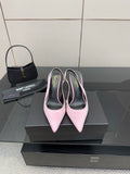 Pink pointed-toe stiletto heels, pair on black shoebox with heel tips visible