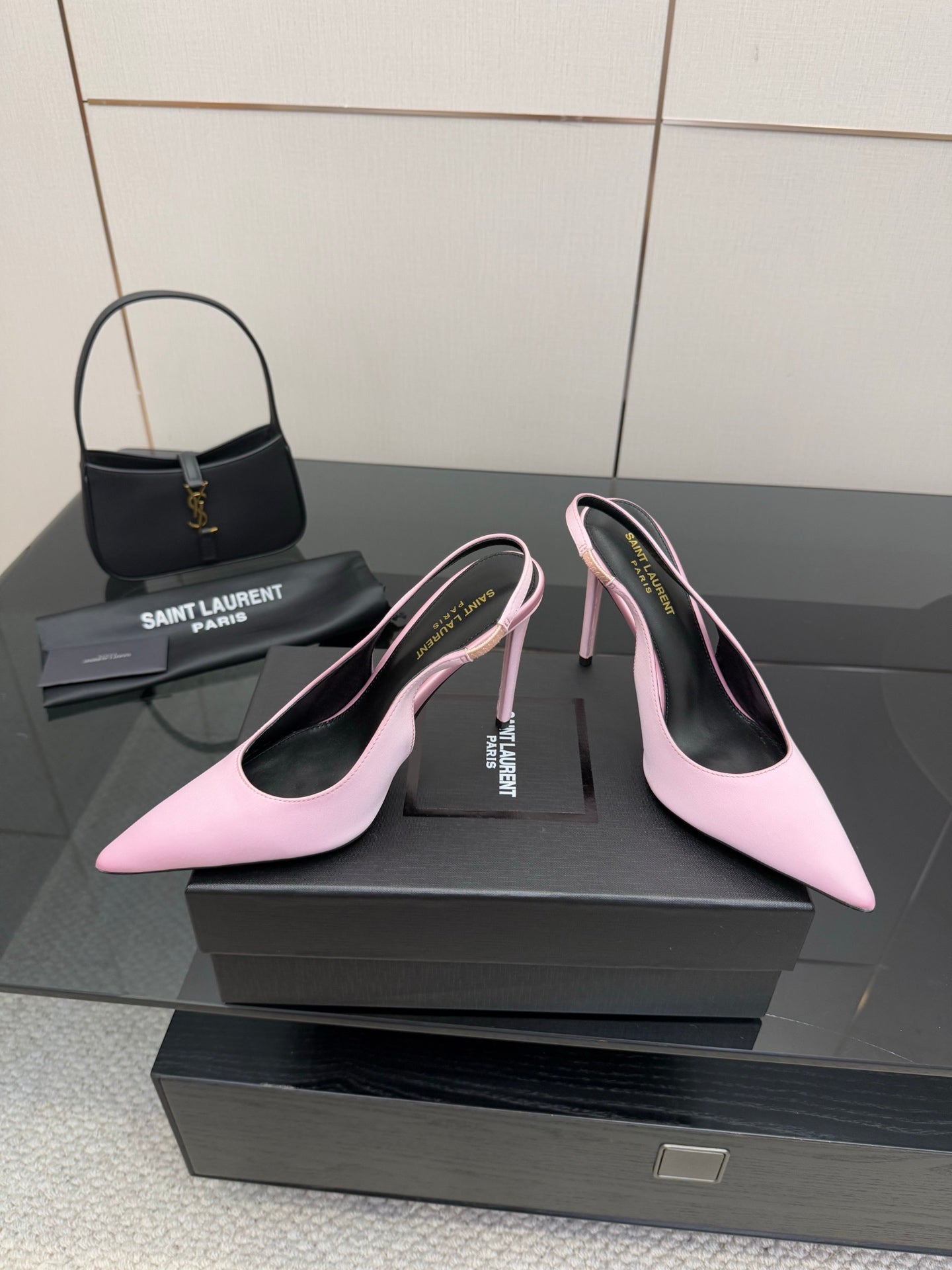 Pink pointed-toe stiletto heels, three-quarter view with black interior and branding