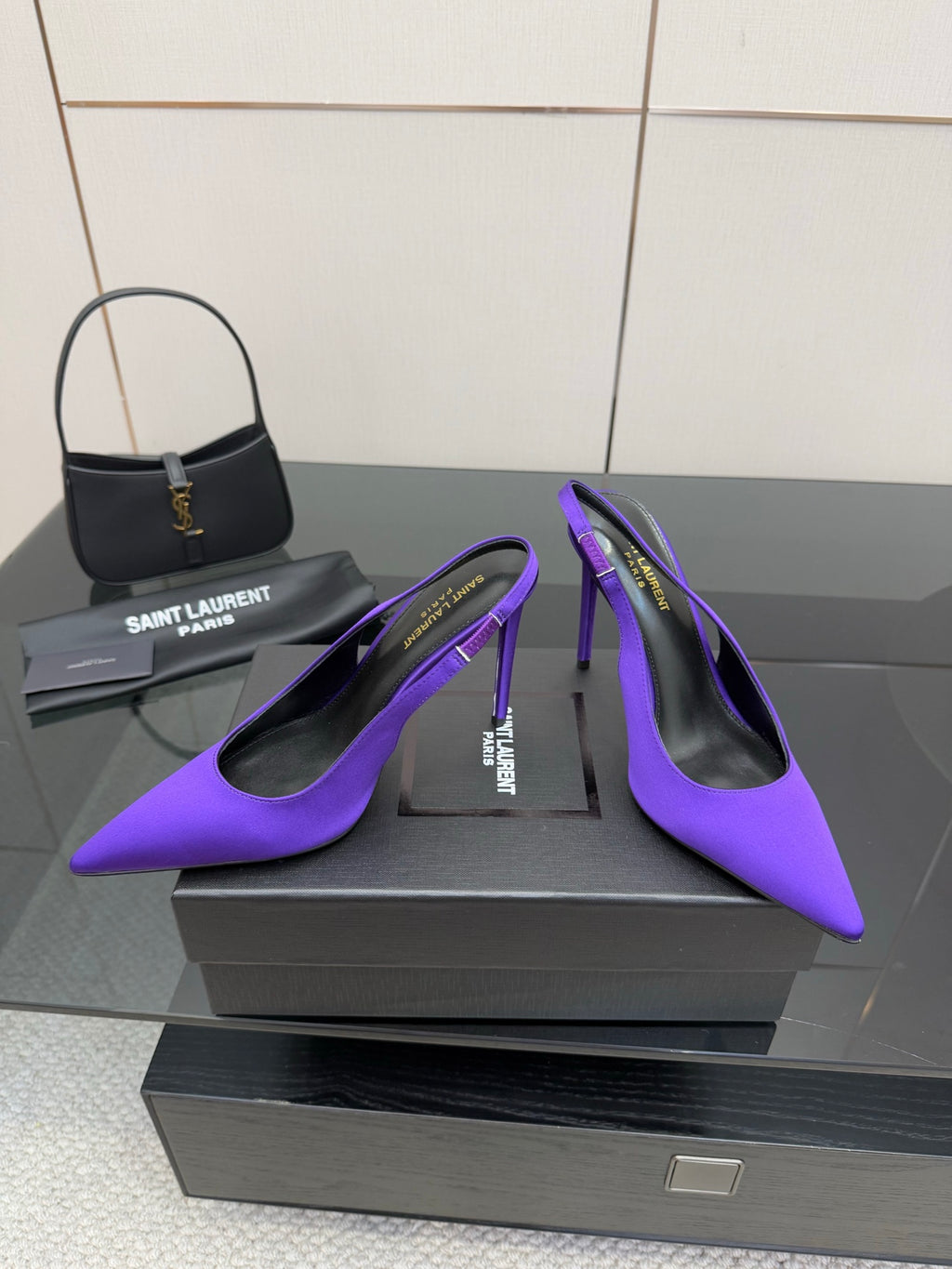 Purple pointed-toe stiletto pumps, front angled view with slender heels.