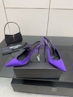 Purple pointed-toe stiletto pumps, front angled view with slender heels.