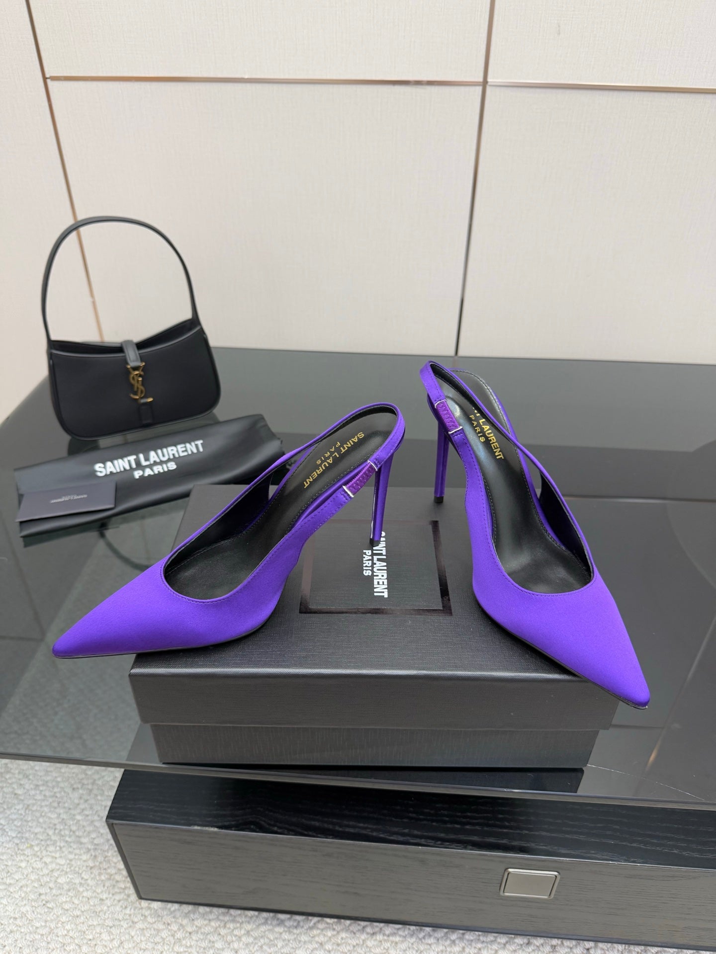 Purple pointed-toe stiletto pumps, front angled view with slender heels.