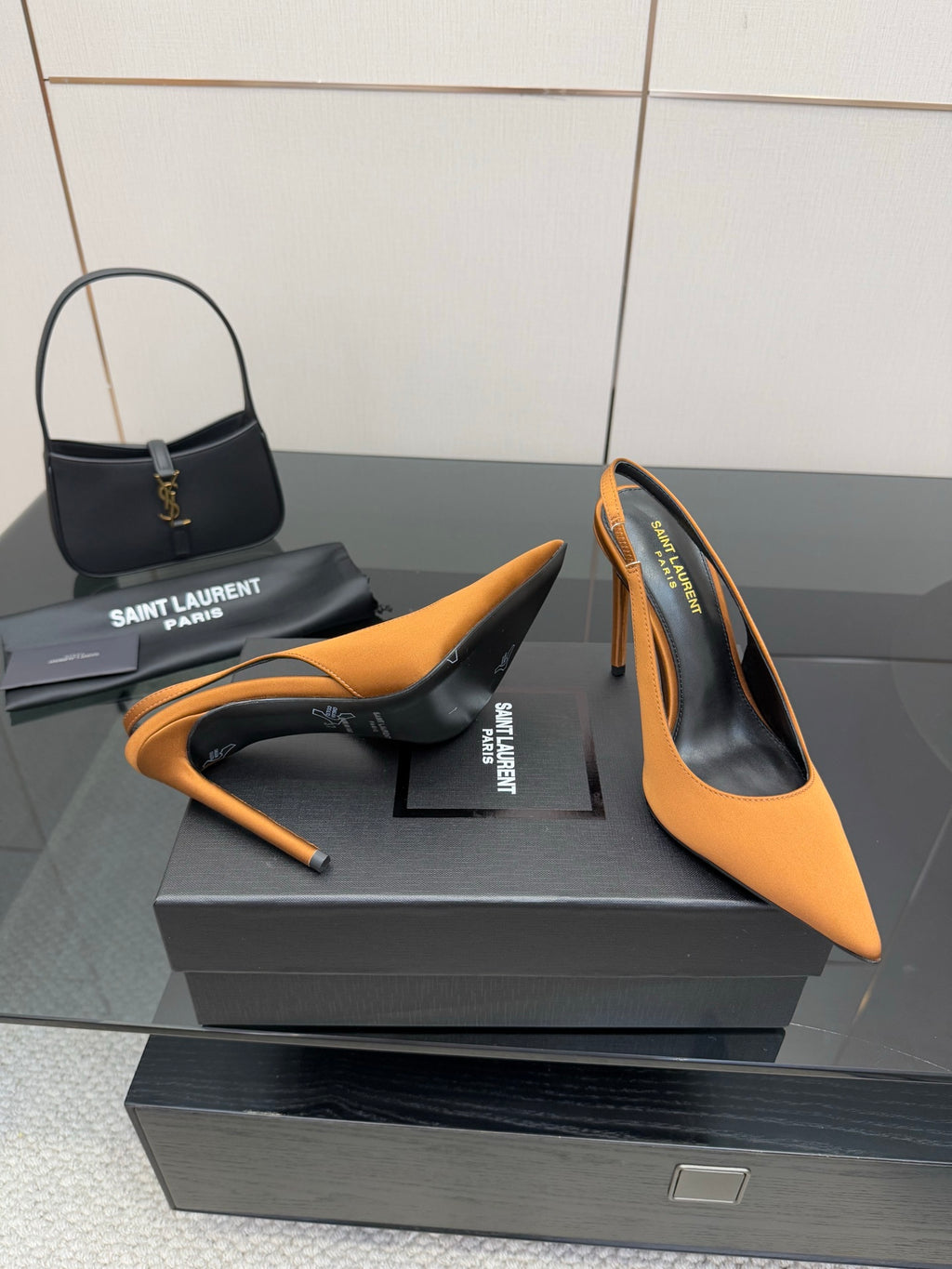 Orange pointed-toe high-heel pumps with stiletto heels on display