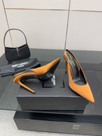 Orange pointed-toe high-heel pumps with stiletto heels on display