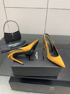 Yellow pointed-toe high-heel pumps with black footbed and slender stiletto heel