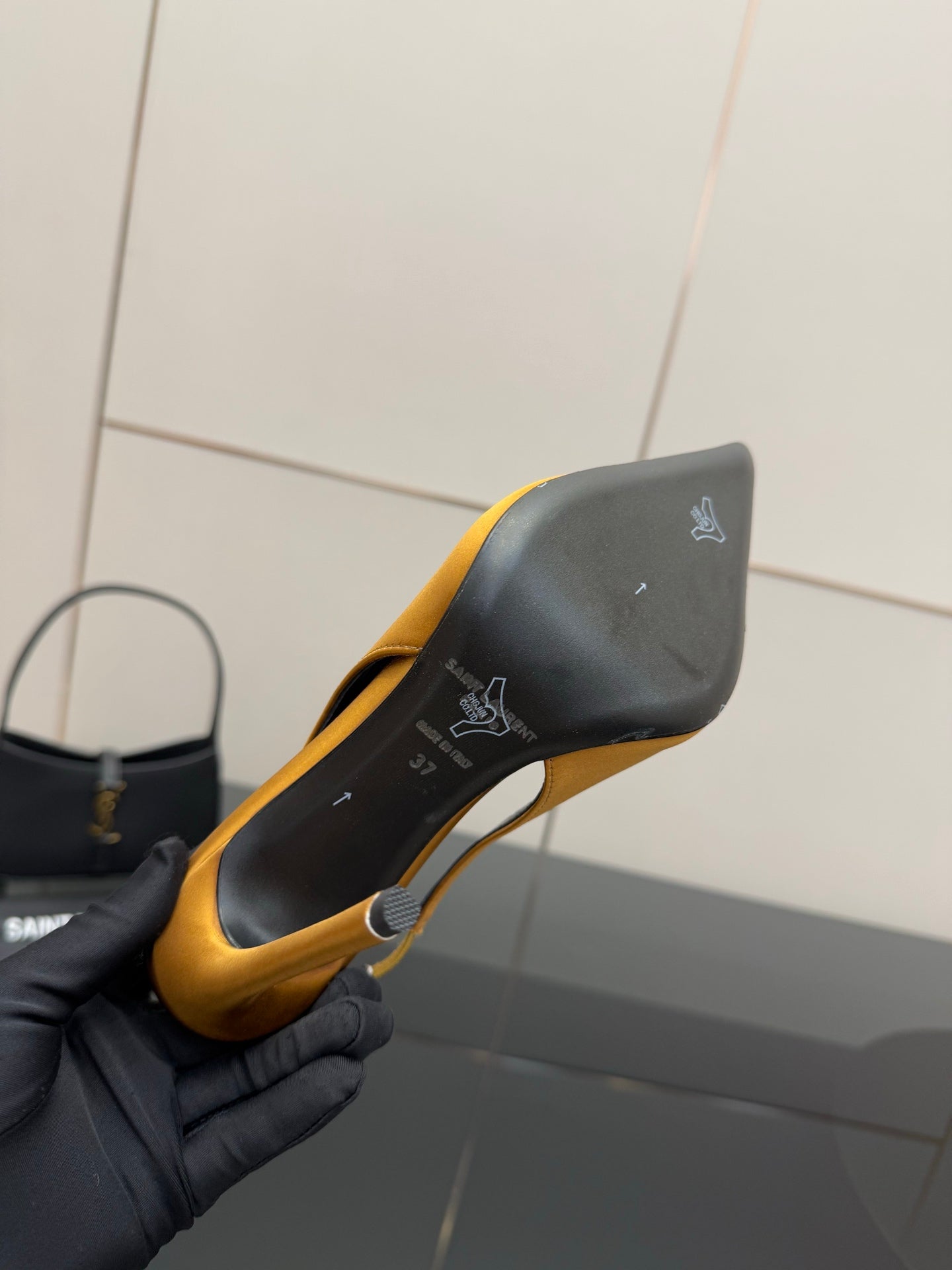 Yellow pointed-toe stiletto pump heel shown close-up with black sole detailing