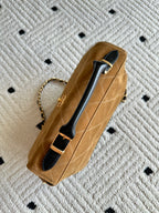 Designer handbag in tan with gold chain and black top handle with logo clasp