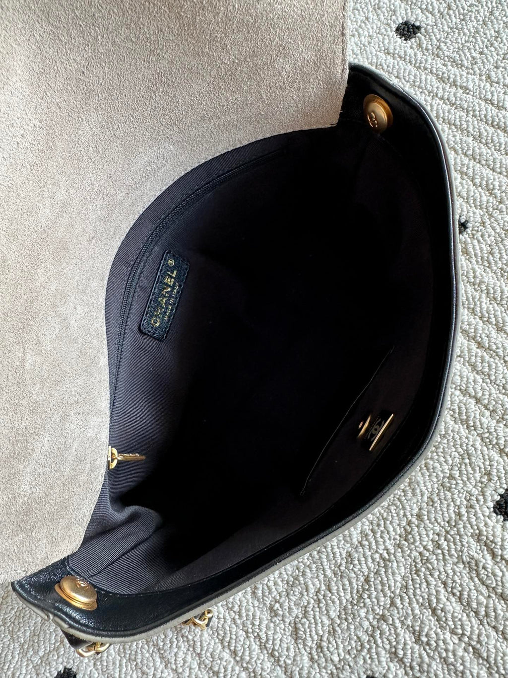 Chanel bag interior view with dark lining and gold-tone hardware at top