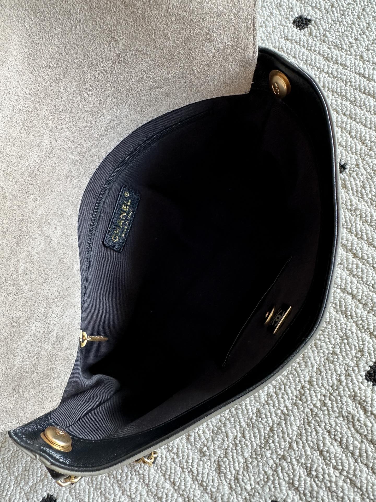 Chanel bag interior view with dark lining and gold-tone hardware at top