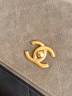 Chanel bag close-up of gold CC logo hardware on beige fabric