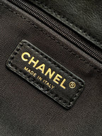 Chanel bag label reading CHANEL MADE IN ITALY on black leather