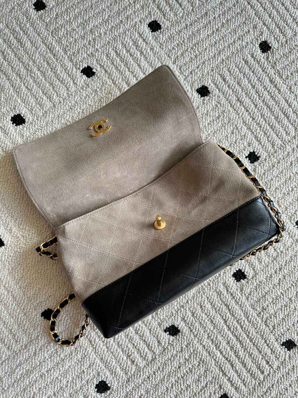 Chanel bag with flap open, beige upper section and black lower section, gold hardware