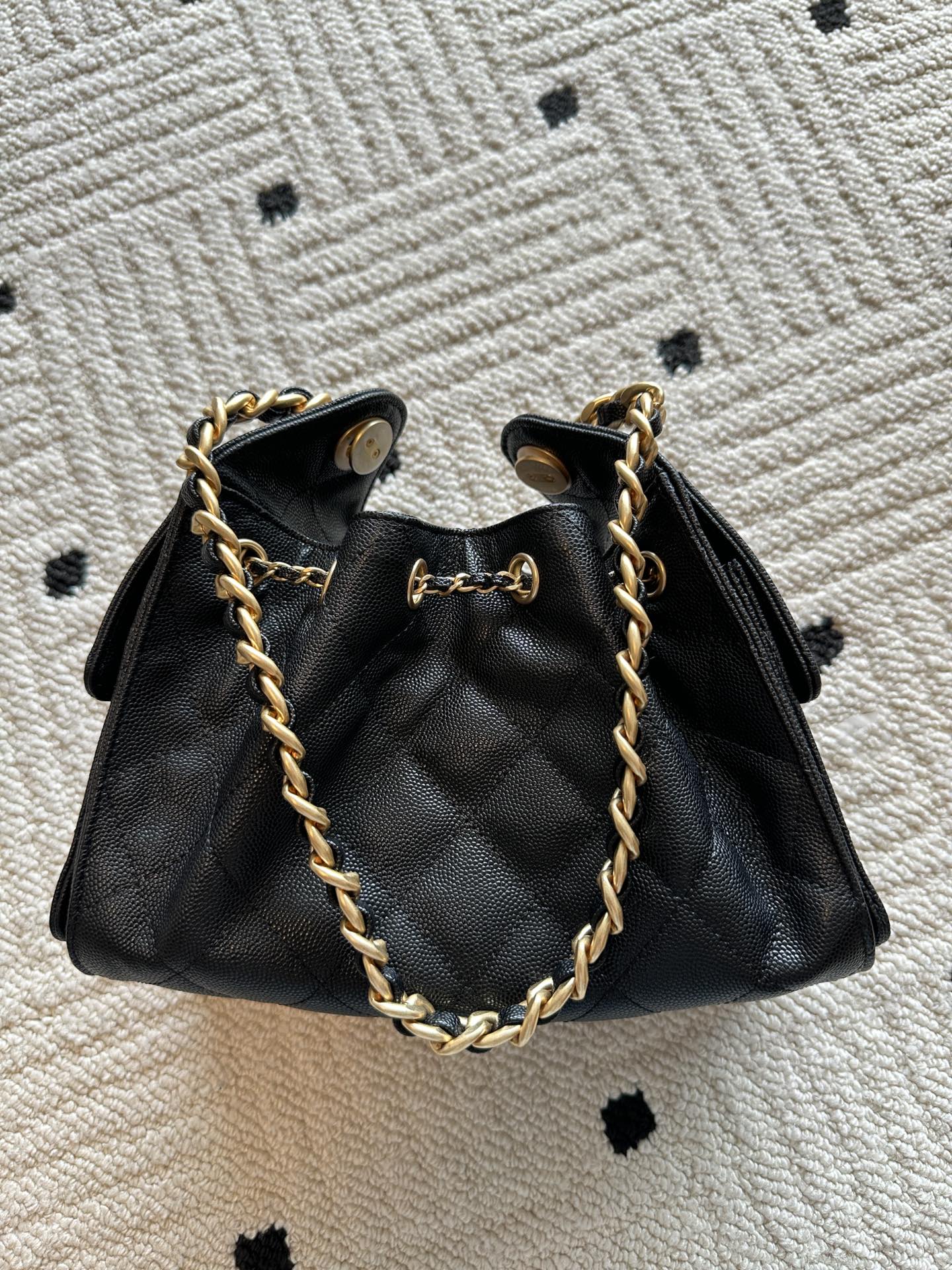 Chanel bag, black leather bucket with gold chain strap and dangling CC emblem