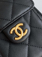 Chanel bag detail, gold CC logo on black quilted leather flap