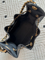 Chanel bag interior view, open black leather bucket with gold chain strap