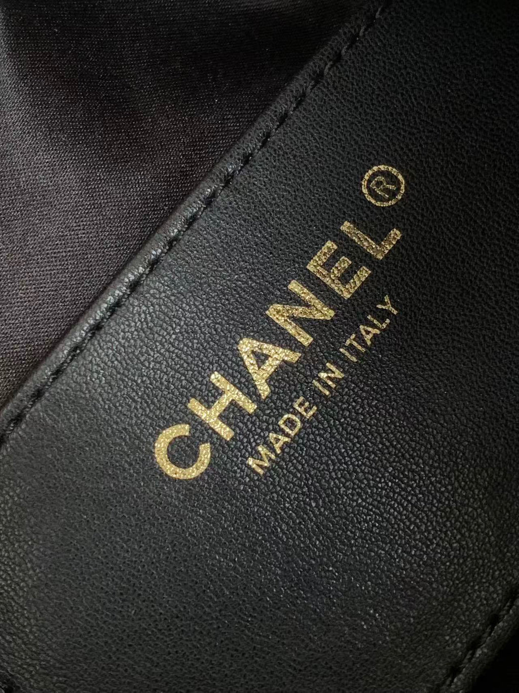 Chanel bag label, CHANEL logo and MADE IN ITALY on black leather