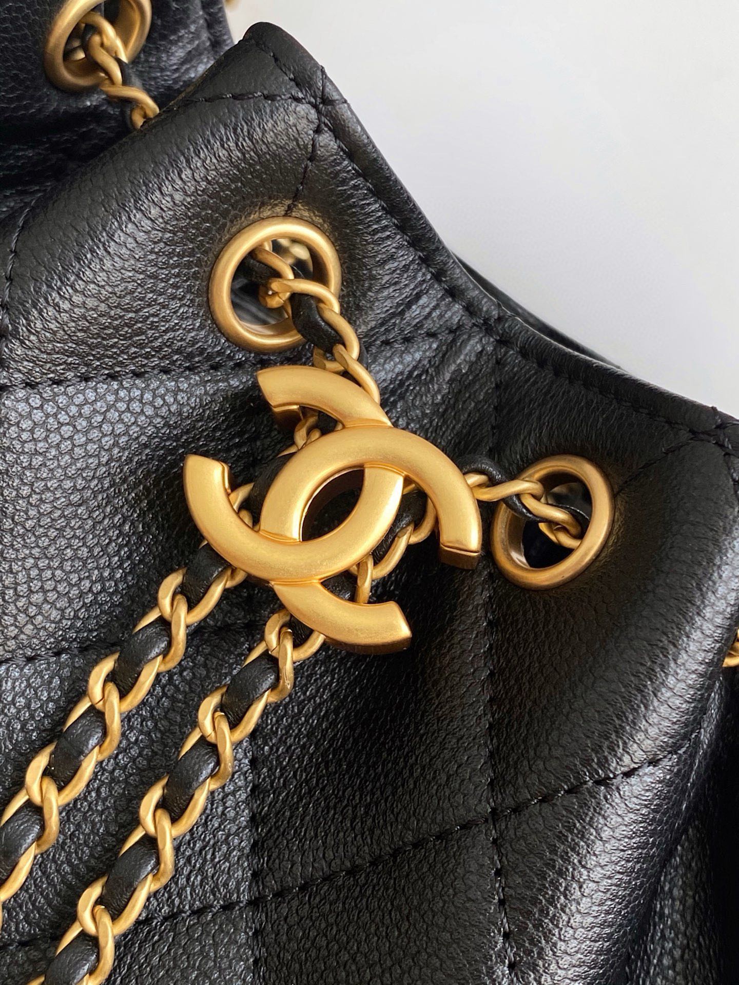 Chanel bag detail, black leather and gold chain with interlocking CC hardware