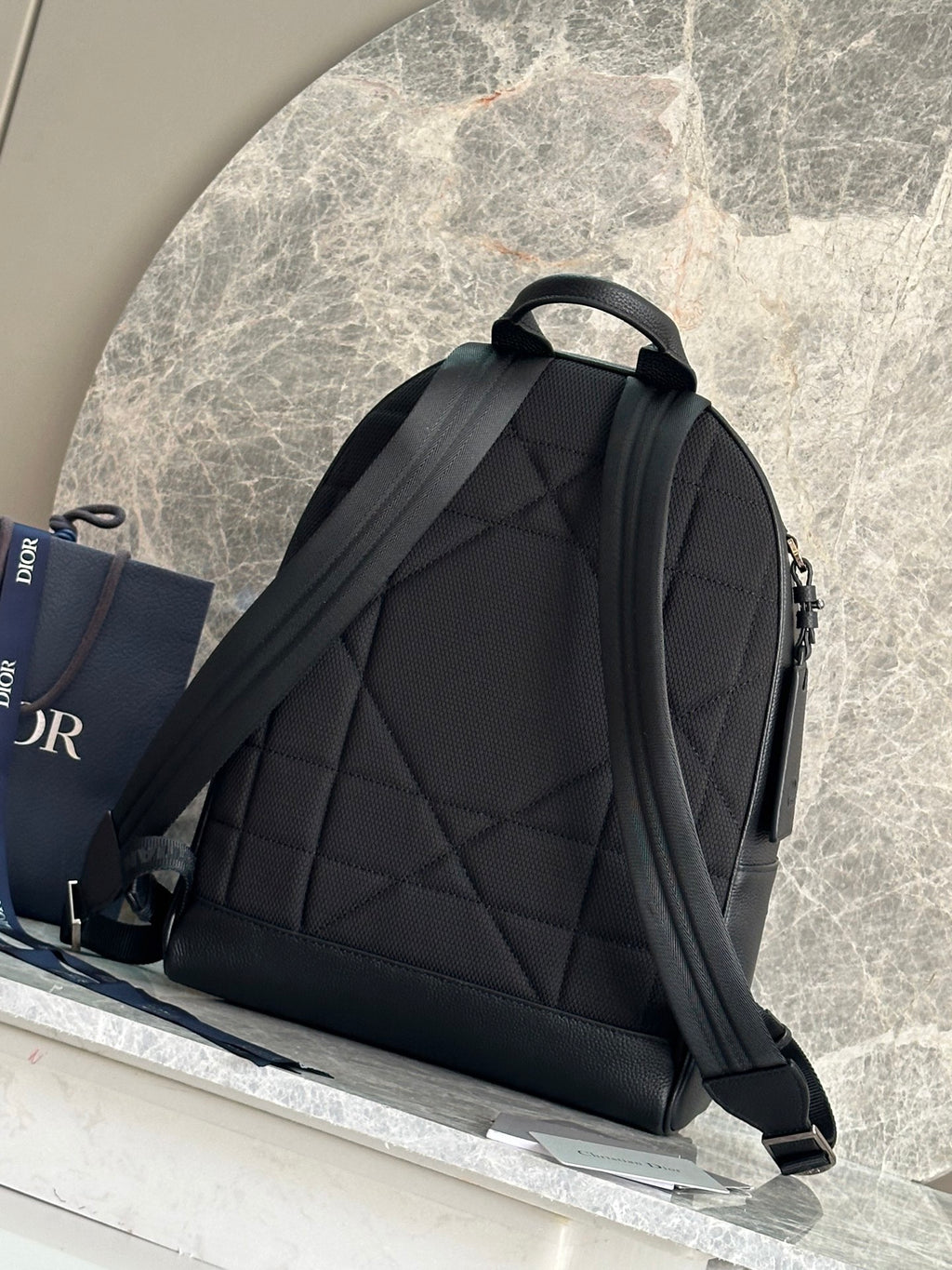 Dark green leather-look backpack with quilted panel and adjustable shoulder straps.
