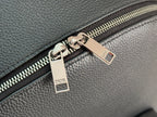 Close-up of silver-tone zipper and metal zipper tags on dark green bag.