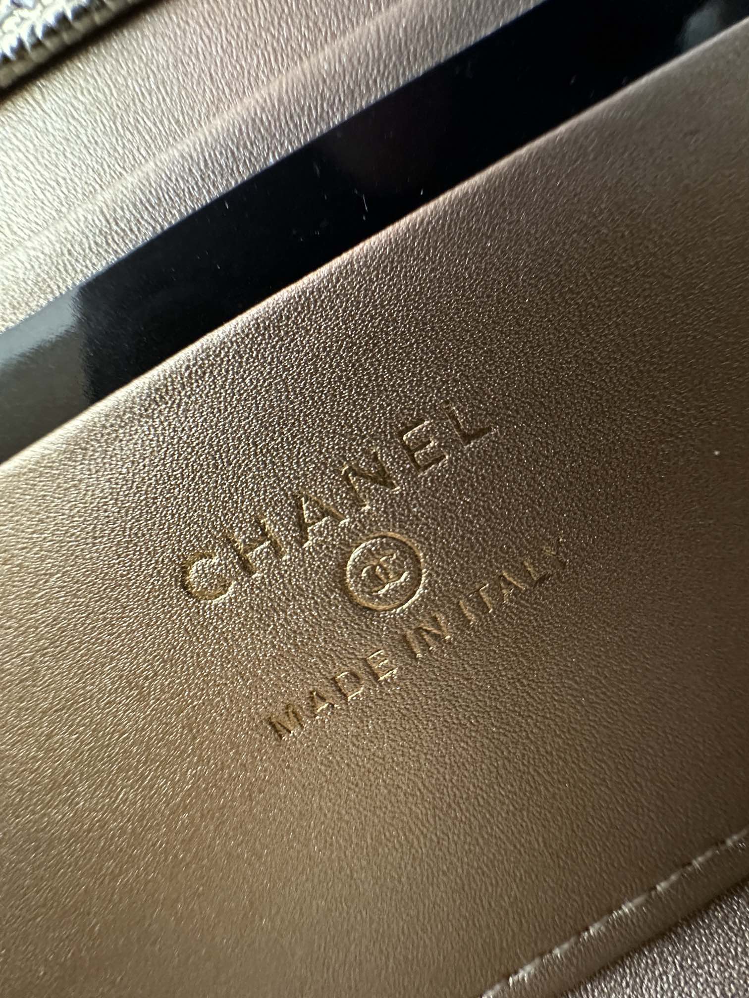 Chanel leather bag exterior close-up with embossed logo text