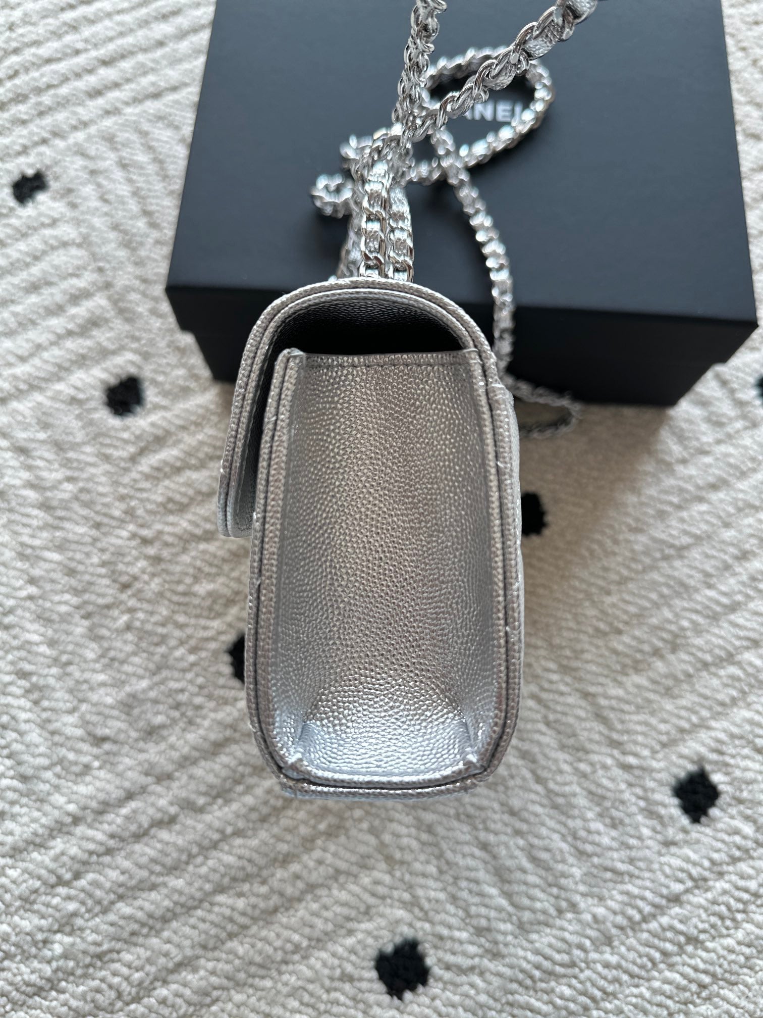 Light silver small crossbody bag with chain strap, rounded top, and zipper compartment