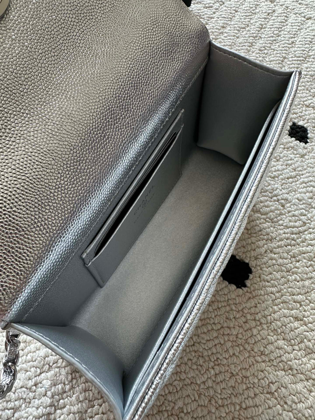 Light silver bag interior opening with smooth lining and stitched inner seams