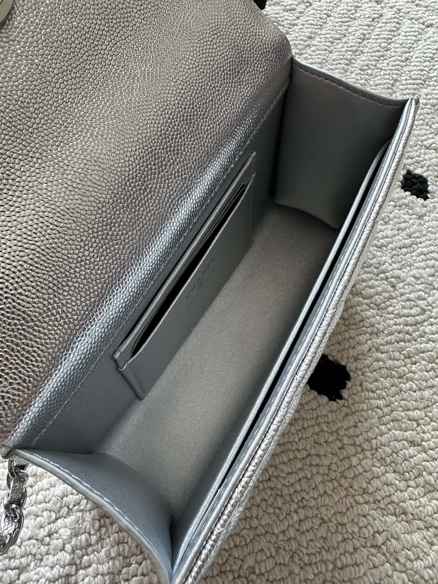 Light silver bag interior opening with smooth lining and stitched inner seams