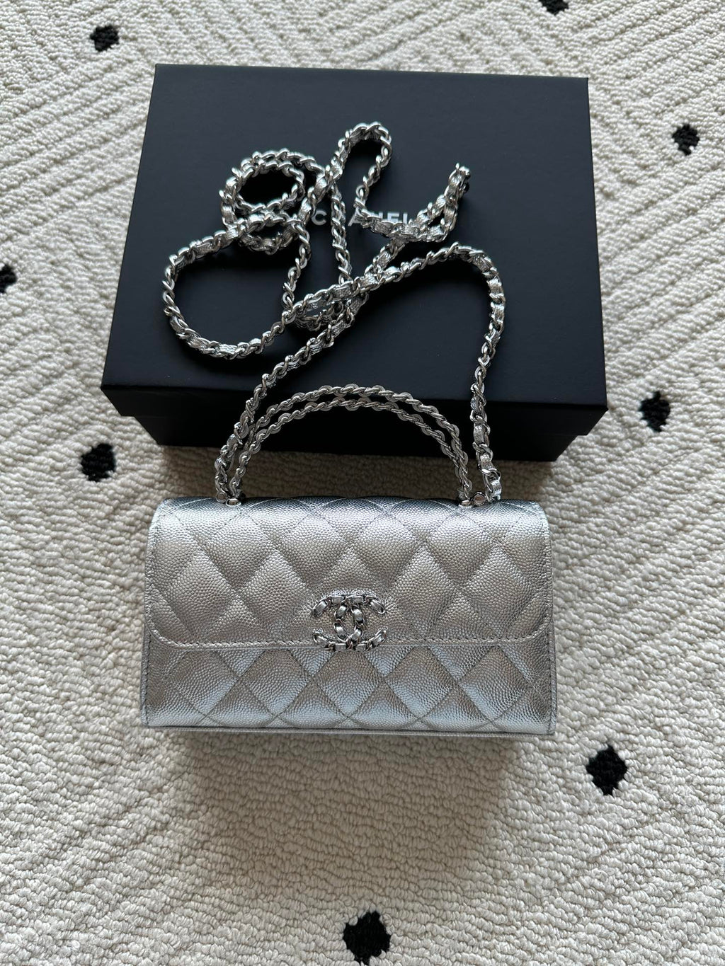 Chanel quilted flap bag in light silver with top handle and chain shoulder strap