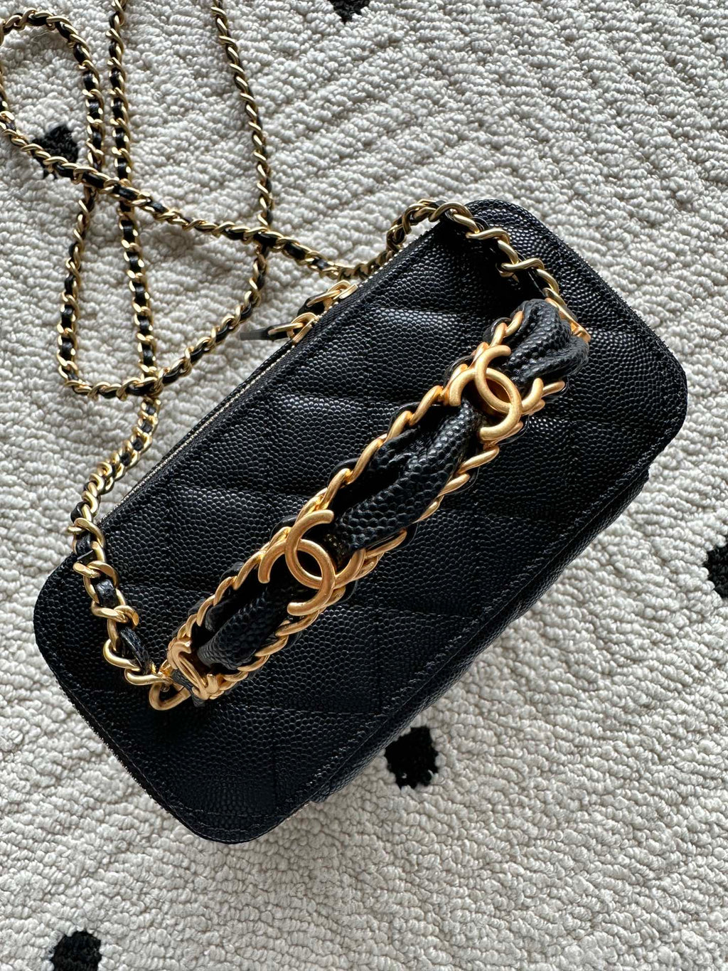 Black quilted shoulder bag with gold chain strap and metal hardware