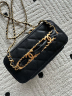 Black quilted shoulder bag with gold chain strap and metal hardware