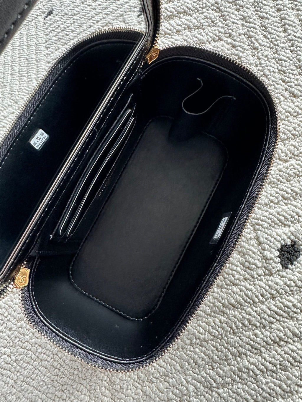 Black lined handbag interior with zippered compartment and top storage slots