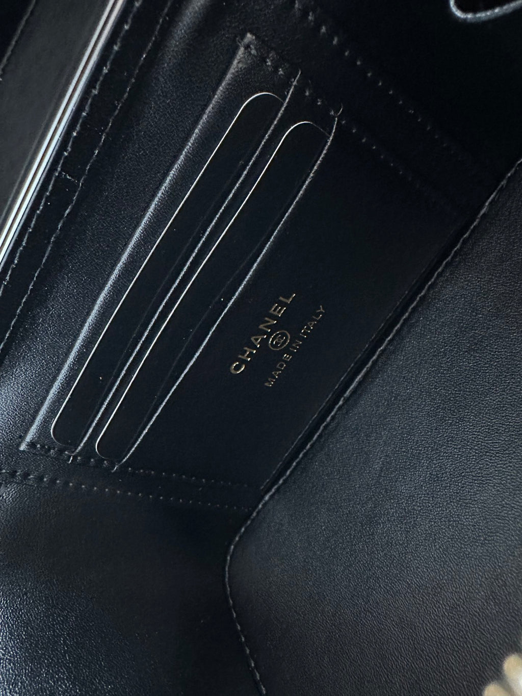 Black leather lining with embossed CHANEL text and stitched compartment seams