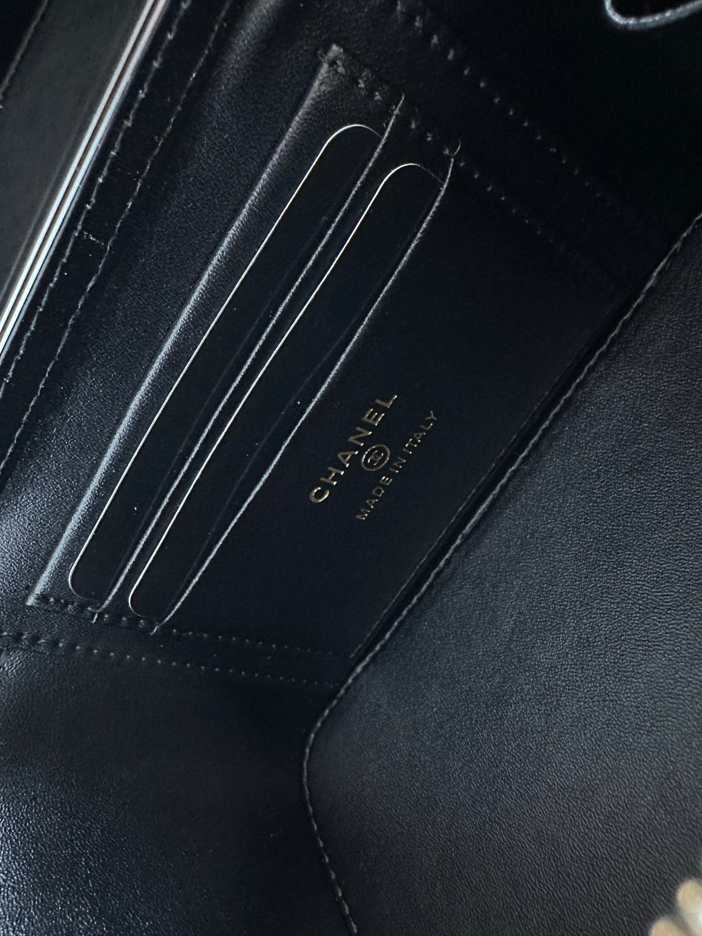 Black leather lining with embossed CHANEL text and stitched compartment seams