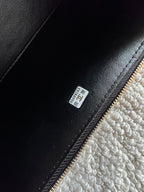 Black leather interior label near zipper trim on handbag