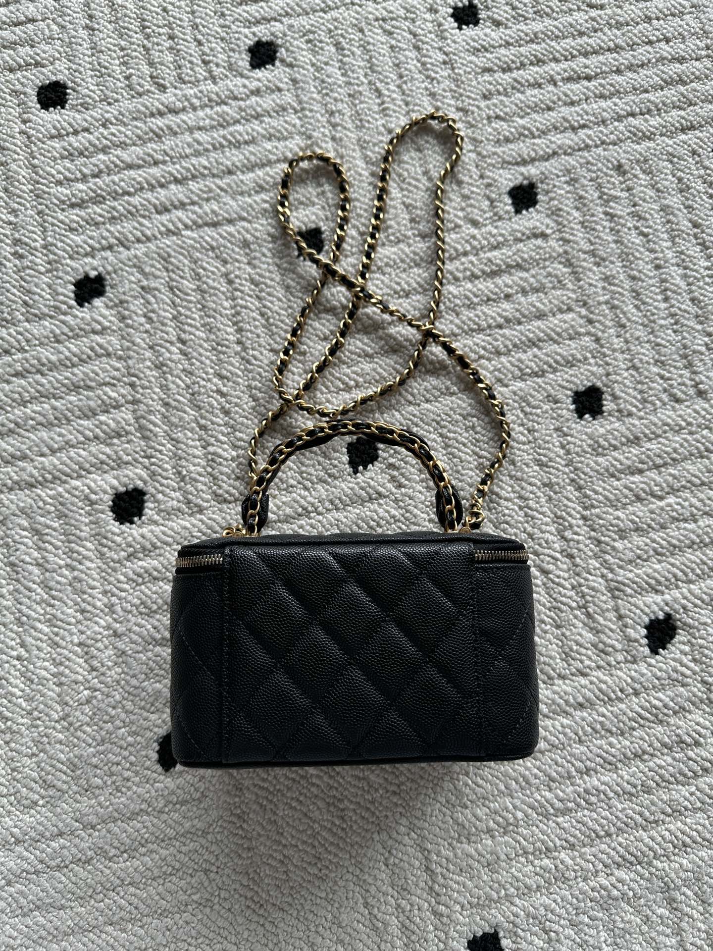 Small black quilted handbag with gold chain strap and CC logo on front