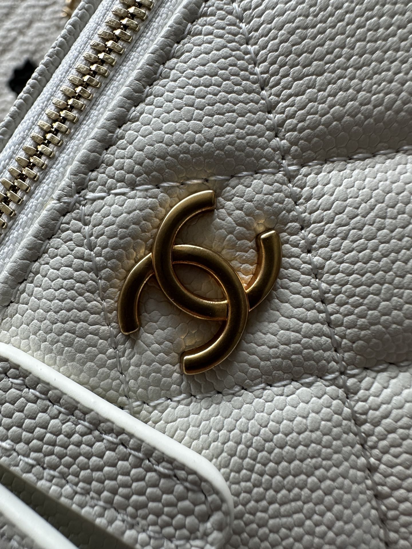 White quilted mini handbag with gold-tone CC charm on the front
