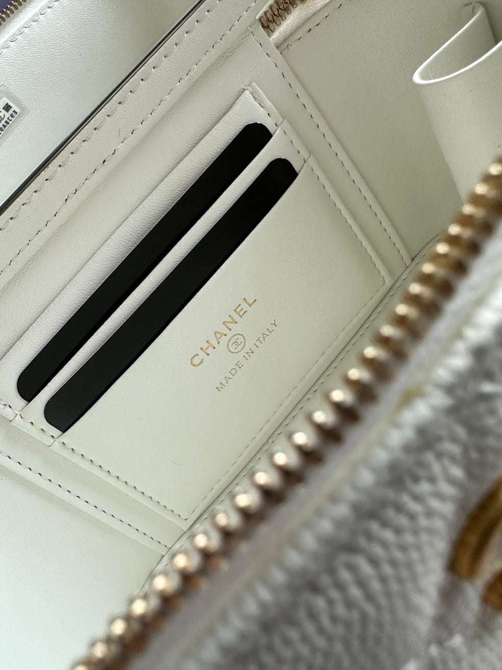 White interior card slot with gold Chanel branding and black stripe pocket