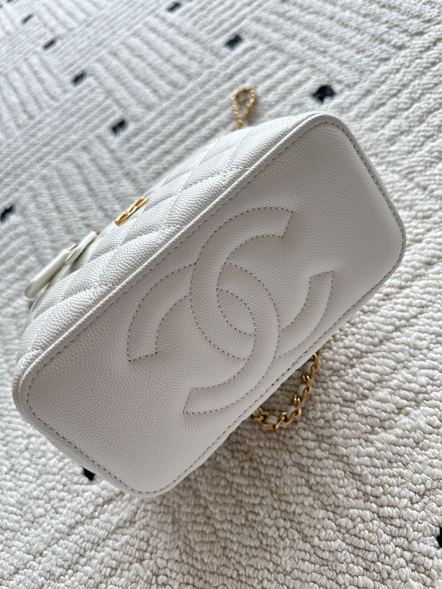 White quilted mini handbag with raised CC logo and short gold chain