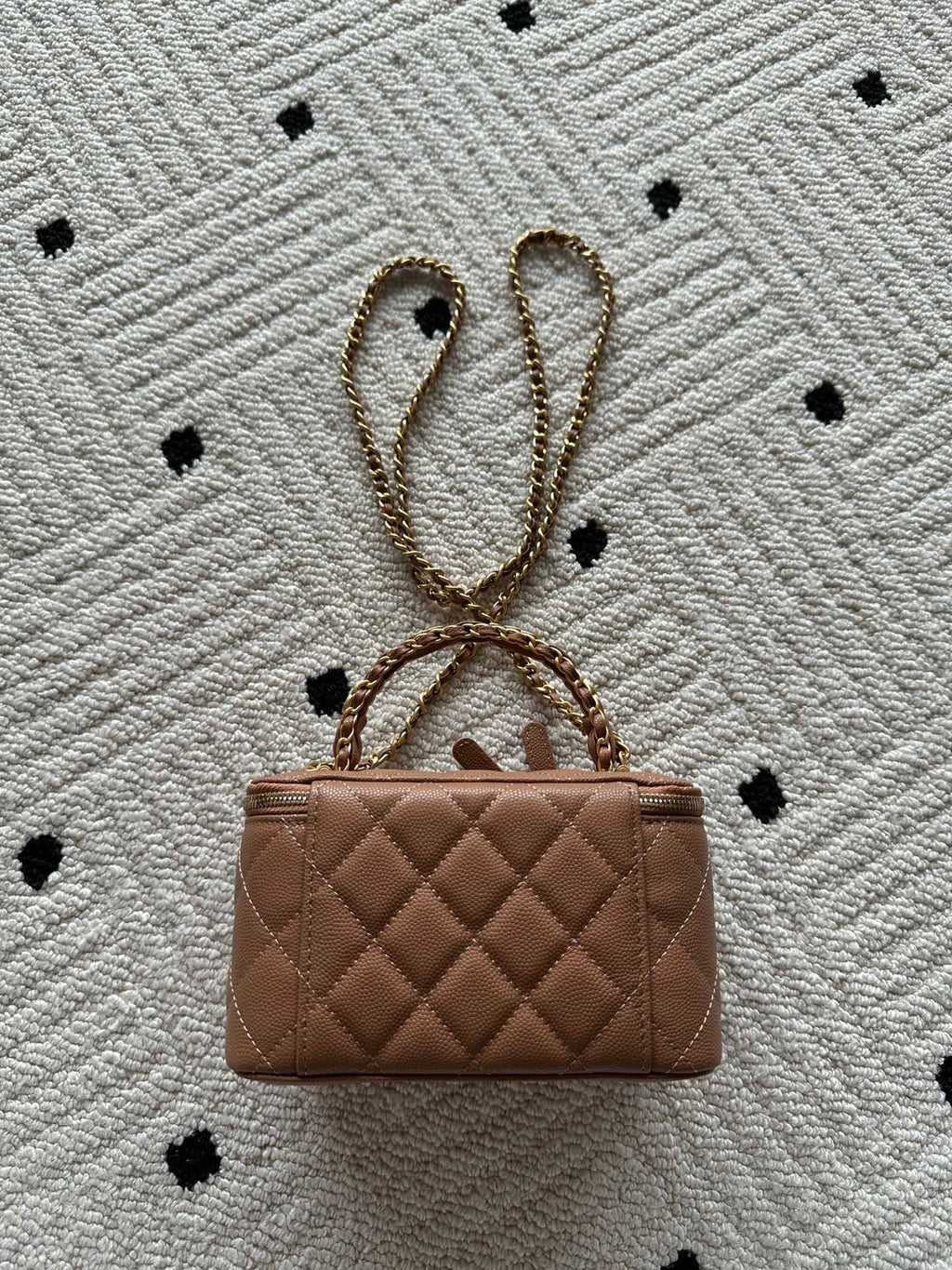 Chanel bag in tan-brown quilted leather with chain strap and small top clasp.