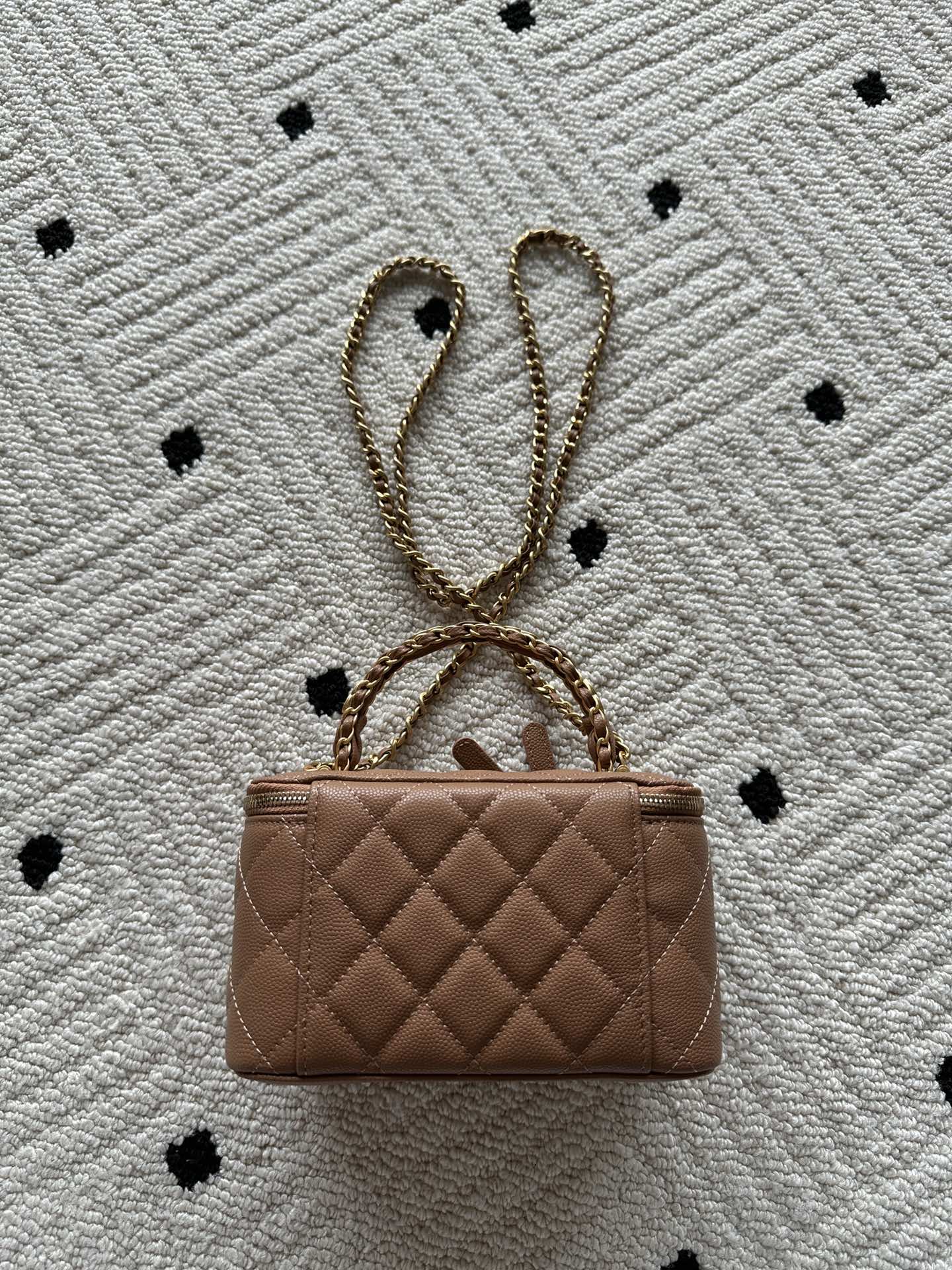 Chanel bag in tan-brown quilted leather with chain strap and small top clasp.