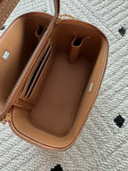 Chanel bag interior view in tan-brown leather with card slots and zip pocket.