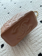 Chanel bag tan-brown quilted leather with embossed CC on front flap.