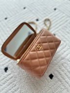 Chanel bag tan-brown quilted leather with zipper and CC logo front.