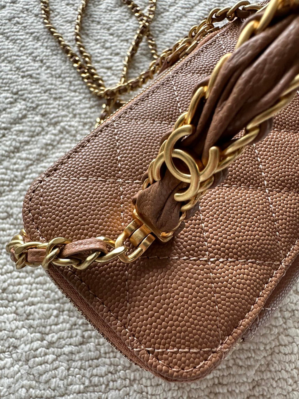 Chanel bag tan-brown quilted leather with gold-tone chain on front flap.