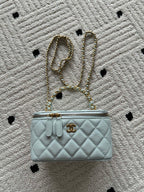 Quilted light-blue mini shoulder bag with gold chain strap and front logo turn-lock