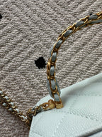 Gold-tone chain and clasp on a light-blue mini quilted bag